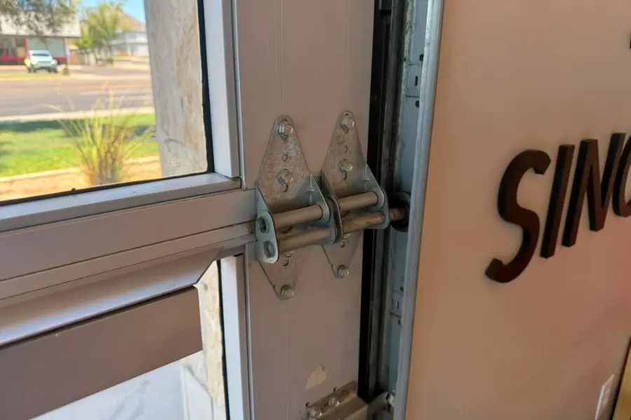A roller and bracket at the head of a commercial overhead door track