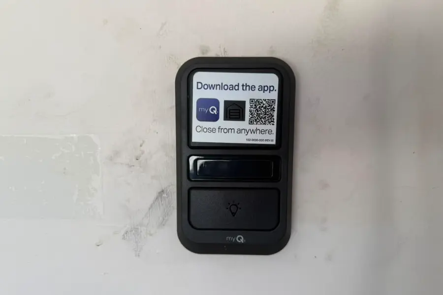 A garage door wall control button mounted beside the door