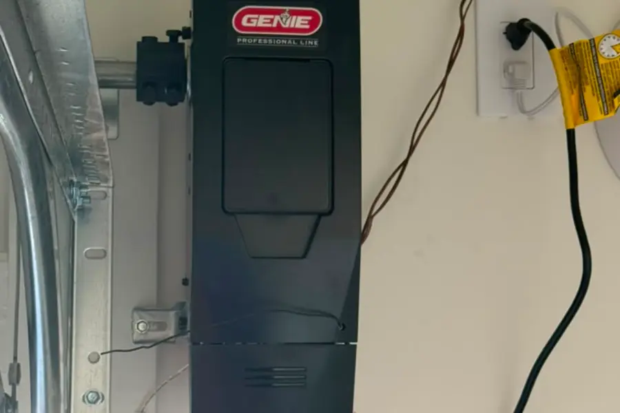 A Genie jackshaft opener mounted on the wall beside a garage door opening