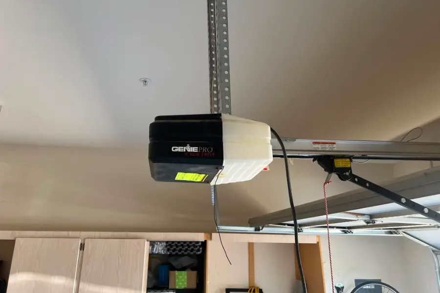 A Genie opener head unit and rail installed in a residential garage
