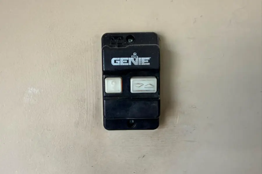 A Genie wall control unit mounted beside the door inside a Chandler garage