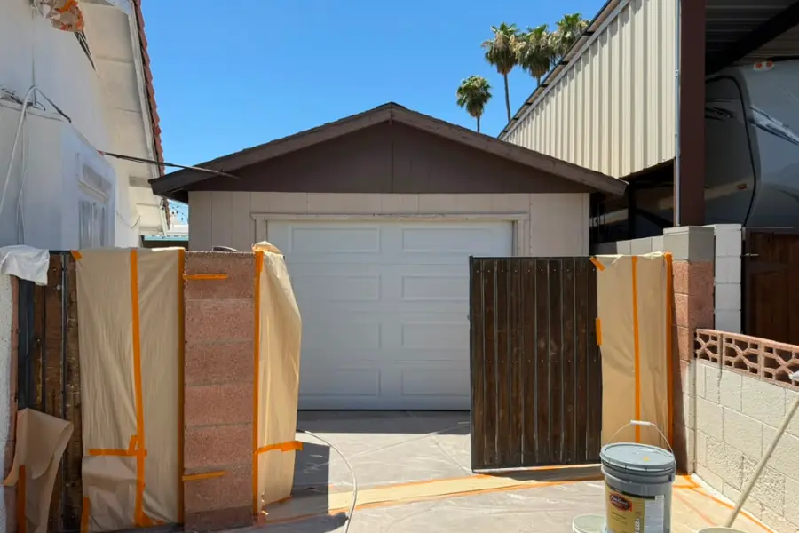 Garage door panel samples propped against a wall outside a home