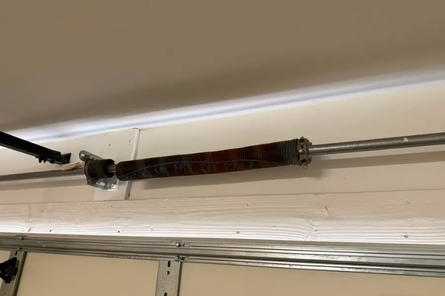 A torsion spring mounted on the shaft above a garage door