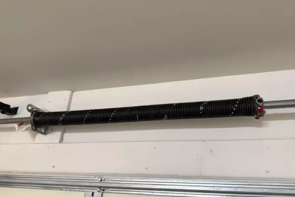 Close view of a torsion spring on a garage door shaft