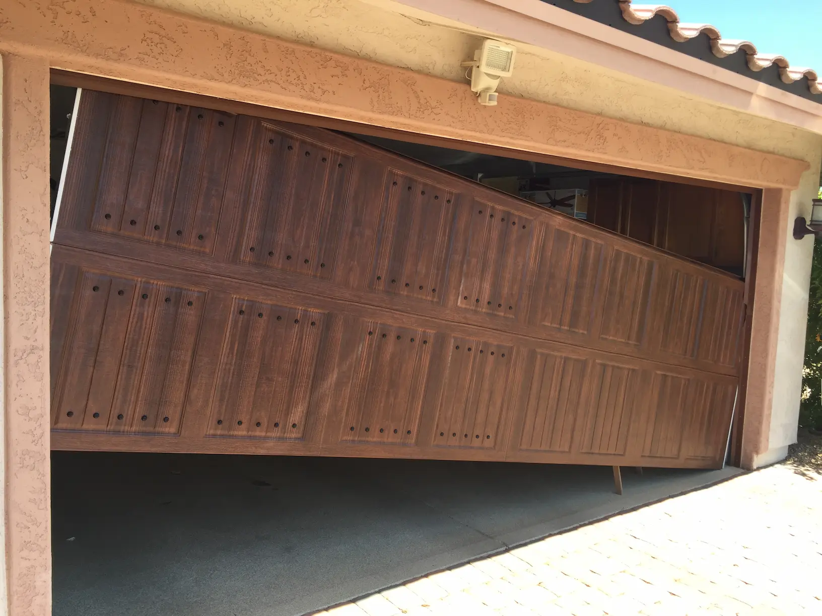 A garage door jammed off its track at an angle