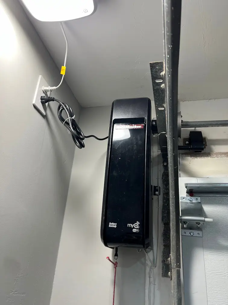A wall mounted LiftMaster myQ opener installed beside a garage door