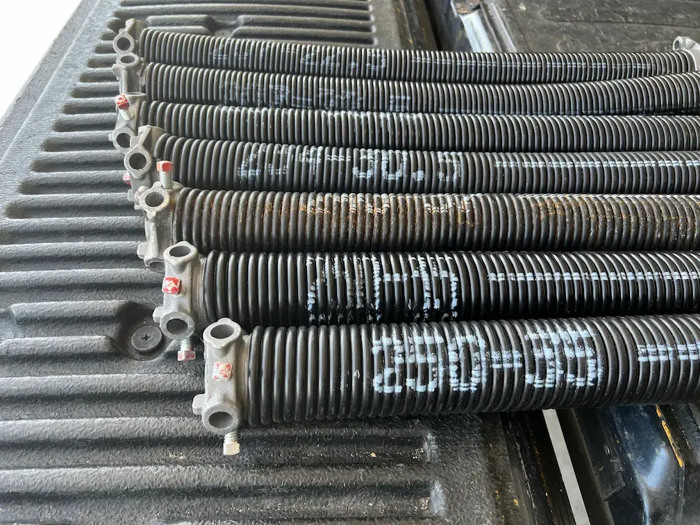 Torsion springs on the truck, marked with their wire size and length